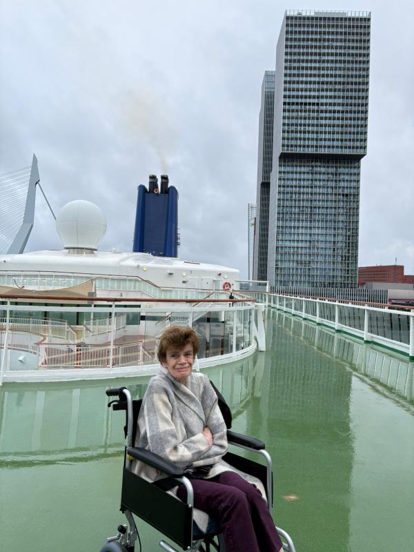 Kate sits on the top deck of a cruise ship in her wheelchair.