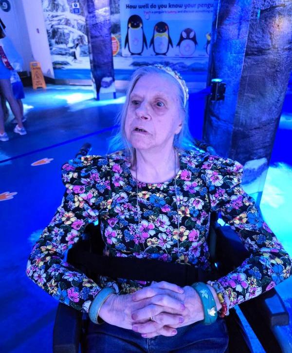 Linda at  SEA LIFE with a penguin display behind her.