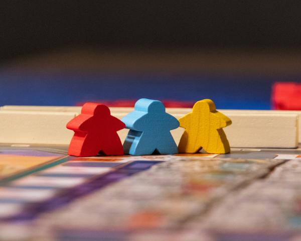wooden people shaped pieces stood holding hands in a line