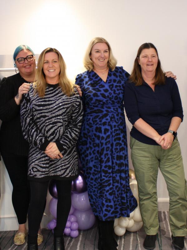 Janice (in blue - third from left) stands with three colleagues at a recent celebration event.