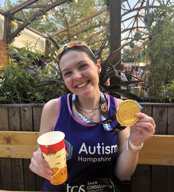 Marathon runner Poppy Hart smiles at the camera with her medal