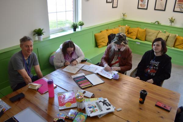 Four people sit around a table being creative in Bordon.