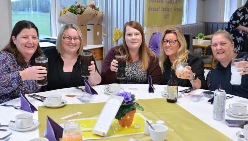 Autism Hampshire staff sit at a table smiling at the camera.