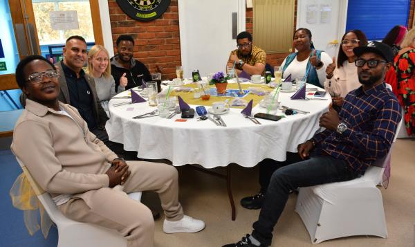 Autism Hampshire staff sit at a table smiling at the camera.