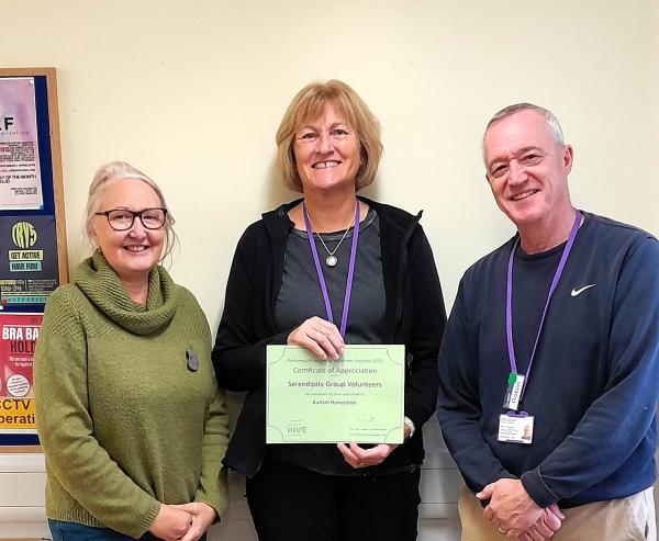 Three of our Portsmouth volunteers smile at the camera holding the certificate.