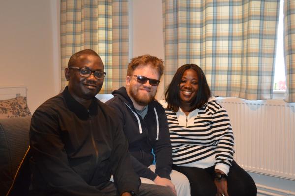 Matt and two of his support workers in his flat.