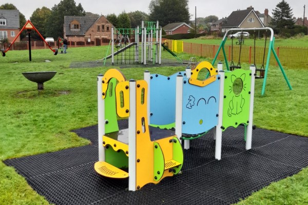 A photo of some swing sets and climbing frames in a playground